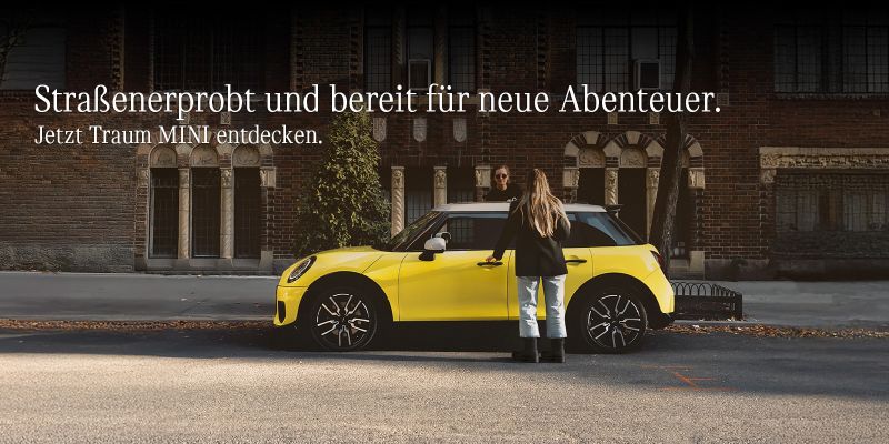 Vergessen Sie Ihren alten Schlitten. Jetzt Traum MINI entdecken. Ein roter MINI, eine Frau und ein Mann mit einem Weihnachtsbaum.